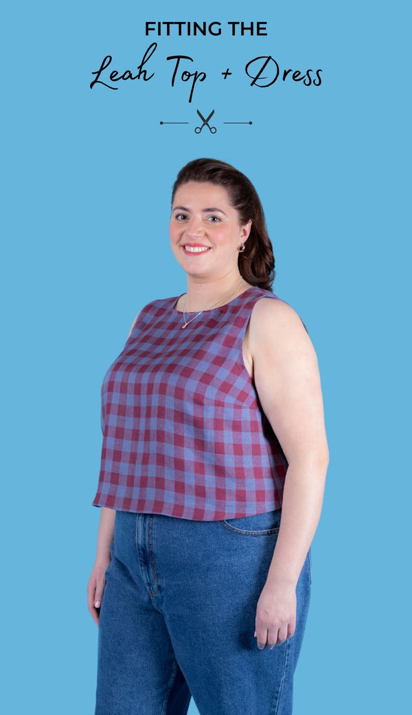 Model wearing the shift top version of the Leah sewing pattern in burgundy and blue gingham fabric, against a blue background. With the title text 'Fitting the Leah top + dress'